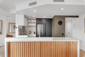 a kitchen with white walls and a wooden counter top at Nouvelle in Noosaville +9 photos