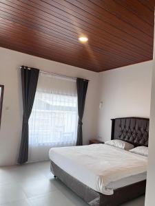a bedroom with a large bed with a wooden ceiling at SALWA Homestay in Kuta Lombok