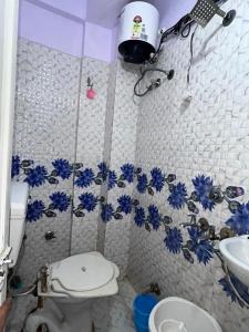a small bathroom with a toilet and a sink at Khandelwal Guest House in Ujjain
