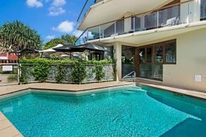 a swimming pool in front of a house at Nouvelle in Noosaville