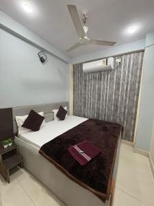 a bedroom with a bed with a ceiling fan at Khandelwal Guest House in Ujjain