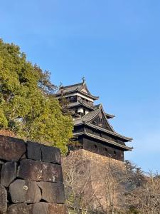 an asian building on top of a stone wall at 喜庵 KIAN the guest house by the castle in Matsue +26 photos