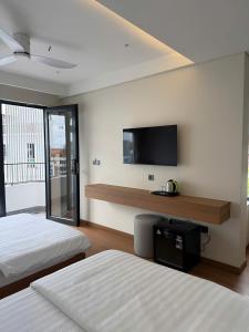 a bedroom with two beds and a flat screen tv at Toàn Thịnh Hotel in Da Lat