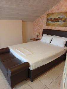 a bedroom with a large bed with a couch at Diamond Maisonette in Kavála +33 photos