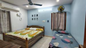a bedroom with a bed and a table in it at P V J RESIDENCY Home Stay in Pithāpuram