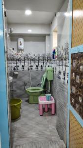 a bathroom with a green toilet and a table at P V J RESIDENCY Home Stay in Pithāpuram