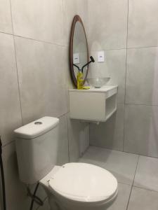 a white bathroom with a toilet and a mirror at Pousada da Neném - Quarto Tangerina in Campina Grande