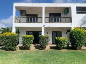 a white house with bushes in front of it at OC Villa in Calodyne