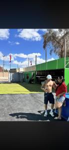 a couple of people standing on a tennis court at hostal y centro de eventos in Chorrillos