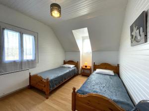 two beds in a room with two windows at Sarthou in Espéchède