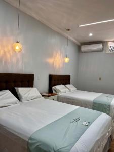 a hotel room with two beds and two lights at Cevero Rodriguez Hotel Boutique in Yurimaguas +8 photos