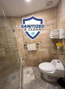 a bathroom with a white toilet and a sign on the wall at Torres Gemelas Suite VIP Frontal 607 in Acapulco +17 photos