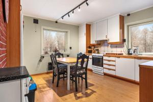 a kitchen with a table and chairs in it at Aurora Lodge in Bjørnevatn