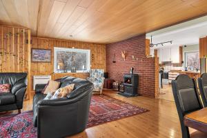 a living room with leather furniture and a brick wall at Aurora Lodge in Bjørnevatn