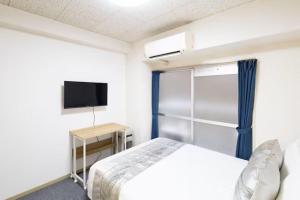 a bedroom with a bed and a tv in a room at コーポラス十日市 - supported by COCOSTAY in Hiroshima