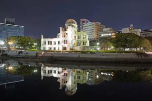 a building with a reflection in the water at night at コーポラス十日市 - supported by COCOSTAY in Hiroshima