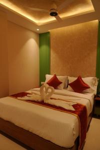 a bedroom with two beds with red and white pillows at Majesty inn in Bangalore +15 photos