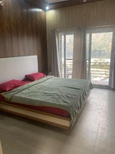 a bedroom with a large bed with red pillows at Nirvana Maldevta in Dehradun