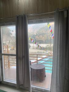 a window in a room with a view of a pool at Nirvana Maldevta in Dehradun