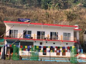 a building with prayer flags in front of it at Nirvana Maldevta in Dehradun +39 photos