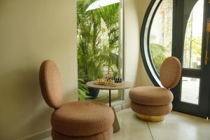 two chairs and a mirror in a room at Ambiance Boutique Art Hotel Karachi in Karachi