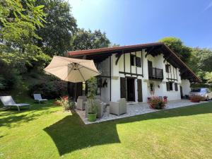 a house with an umbrella in the yard at Chez garcia in Urrugne