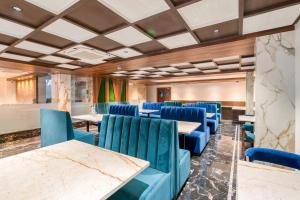a conference room with blue chairs and tables at Hotel Vilvah in Coimbatore