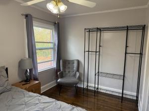 a bedroom with a chair and a bed and a window at Cozy 1 Bedroom Bungalow in Charlotte