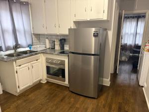 a kitchen with a stainless steel refrigerator and white cabinets at Cozy 1 Bedroom Bungalow in Charlotte
