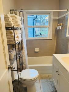 a bathroom with a toilet and a window and towels at Cozy 1 Bedroom Bungalow in Charlotte +12 photos