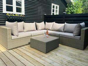 a wicker couch and a table on a patio at Holiday Home At Fynshoved in Martofte