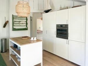 a kitchen with white cabinets and a counter top at Holiday Home At Fynshoved in Martofte