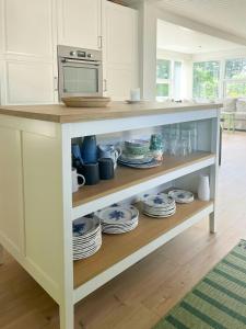 a kitchen with a counter with plates and a microwave at Holiday Home At Fynshoved in Martofte