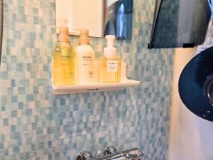 a bathroom with three bottles of soap on a wall at sora in Osaka +127 photos