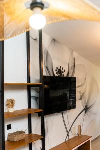 a living room with a flat screen tv on a wall at La Fabrik' - Studio avec jacuzzi privé à La Réunion in Le Tampon