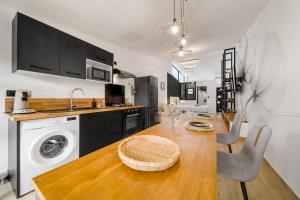 a kitchen with a table and a washing machine at La Fabrik' - Studio avec jacuzzi privé à La Réunion in Le Tampon