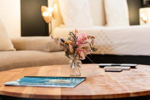 a vase of flowers on a table in a room at La Fabrik' - Studio avec jacuzzi privé à La Réunion in Le Tampon