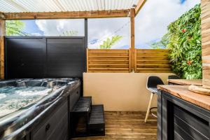 a hot tub in the middle of a patio at La Fabrik' - Studio avec jacuzzi privé à La Réunion in Le Tampon +14 photos