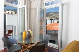 a dining room with a glass table and chairs at BJ Apartments Funchal in Funchal