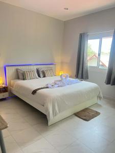 a bedroom with a large bed with white sheets and a window at Samakki Residence - Modern Rooms, Quiet Area, Near the Beach in Rawai Beach