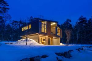 a house in the woods at night in the snow at Eminence in Hakuba