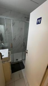 a bathroom with a shower and a white door at Varandas do Porto Coliving in Porto