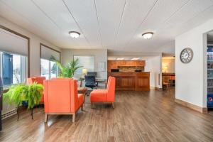 an office lobby with orange chairs and a table at Days Inn by Wyndham International Falls in International Falls