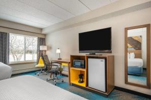 a hotel room with a television and a desk with a chair at Days Inn by Wyndham International Falls in International Falls