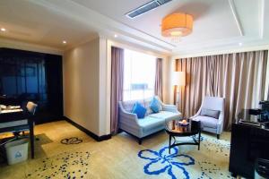 a living room with a couch and chairs in a room at Ramada Plaza Tianlu Hotel in Wuhan