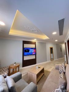 a living room with a couch and a flat screen tv at صفاء المسكن in Dammam