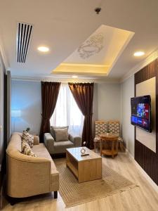 a living room with a couch and a tv at صفاء المسكن in Dammam