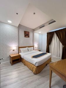 a bedroom with a large bed and a table at صفاء المسكن in Dammam