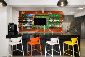 a bar with colorful stools in a restaurant at Decameron Isla Coral Guayabitos, Ramada All-Inclusive Resort in Rincon de Guayabitos