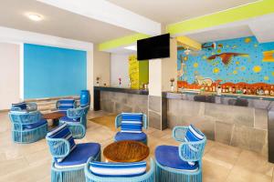 a waiting room with blue chairs and a table at Decameron Isla Coral Guayabitos, Ramada All-Inclusive Resort in Rincon de Guayabitos